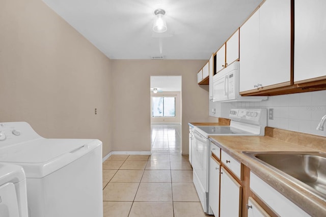 interior space featuring light tile patterned floors, washer and clothes dryer, and sink