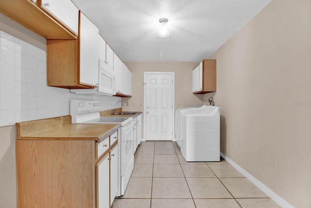 kitchen with white cabinetry, sink, white appliances, light tile patterned floors, and washer and dryer