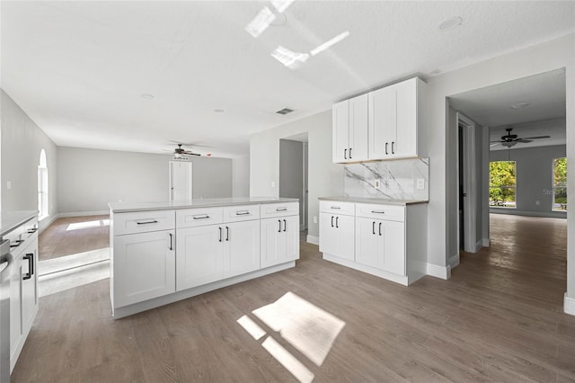 kitchen featuring white cabinets, light wood-type flooring, and backsplash