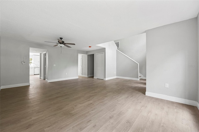 unfurnished living room featuring hardwood / wood-style floors, a textured ceiling, and ceiling fan