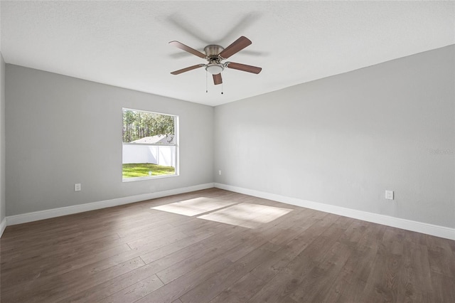 spare room with ceiling fan, dark wood-type flooring, and a textured ceiling