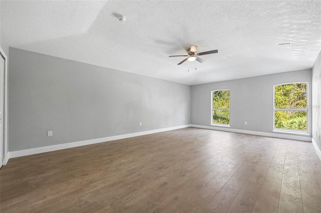 spare room featuring a textured ceiling, ceiling fan, vaulted ceiling, and dark hardwood / wood-style floors