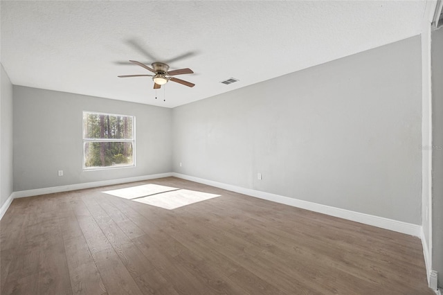 unfurnished room with ceiling fan, dark hardwood / wood-style flooring, and a textured ceiling