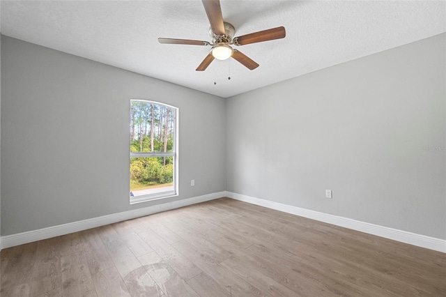 spare room featuring ceiling fan, light hardwood / wood-style floors, and a textured ceiling