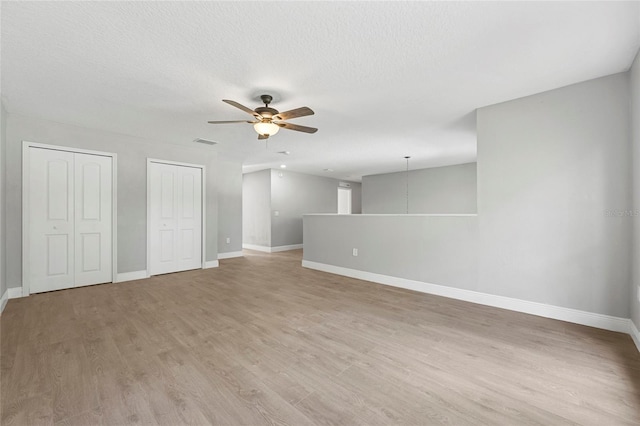 unfurnished room with ceiling fan, light hardwood / wood-style floors, and a textured ceiling