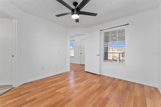 spare room with a textured ceiling, light hardwood / wood-style floors, and ceiling fan