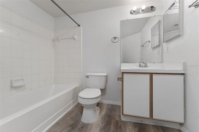 full bathroom featuring vanity, hardwood / wood-style flooring, toilet, and tiled shower / bath