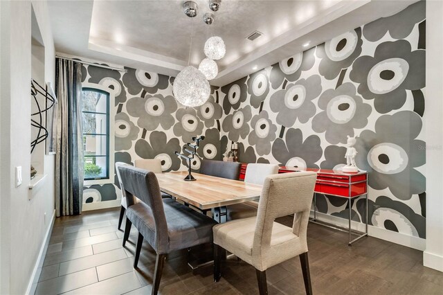 dining room featuring a raised ceiling and hardwood / wood-style floors