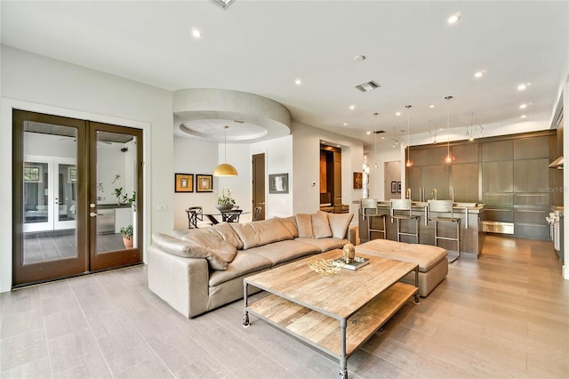 living room with french doors and light hardwood / wood-style floors