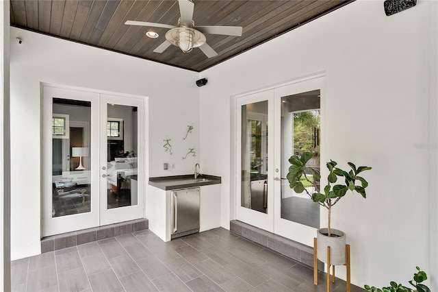 interior space with ceiling fan, french doors, and wood ceiling