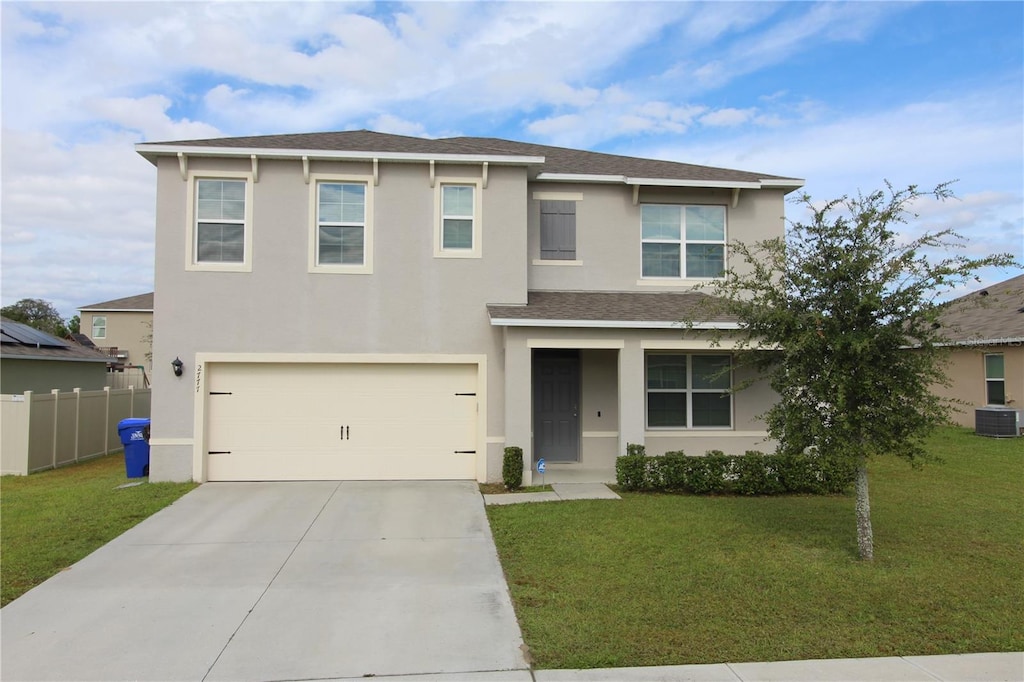 view of front of house featuring cooling unit, a garage, and a front yard