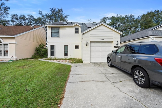 view of front facade featuring a garage, a front yard, and solar panels