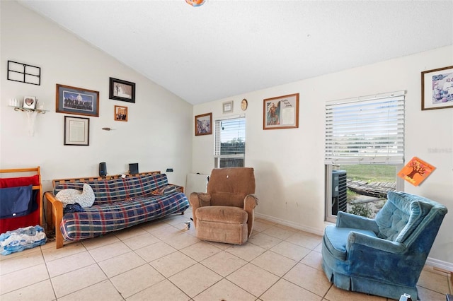 living area with plenty of natural light, light tile patterned floors, and vaulted ceiling