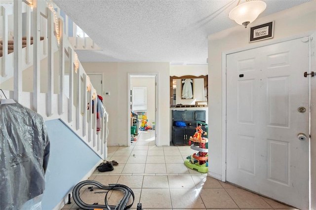 tiled entryway featuring a textured ceiling