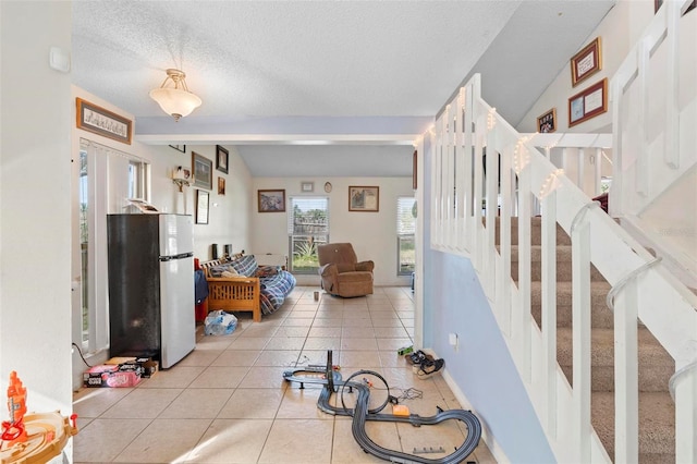 living room with light tile patterned floors, a textured ceiling, and lofted ceiling