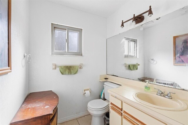 bathroom featuring toilet, vanity, tile patterned floors, and a healthy amount of sunlight