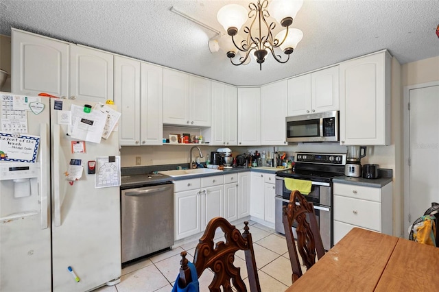 kitchen with white cabinetry, sink, a notable chandelier, light tile patterned flooring, and appliances with stainless steel finishes