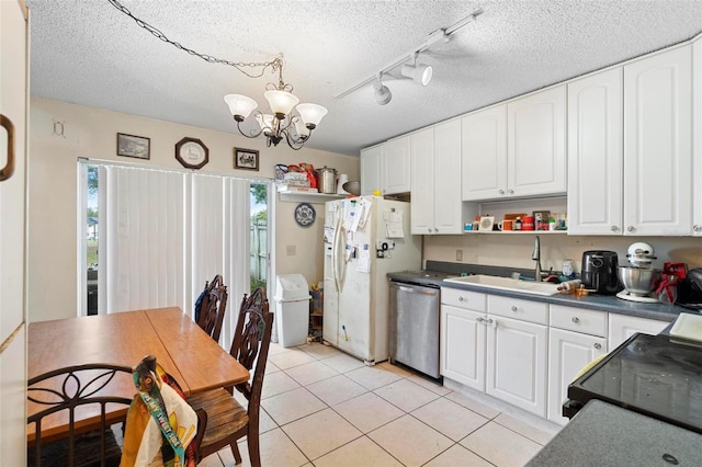 kitchen featuring sink, stainless steel dishwasher, light tile patterned floors, white cabinetry, and a chandelier