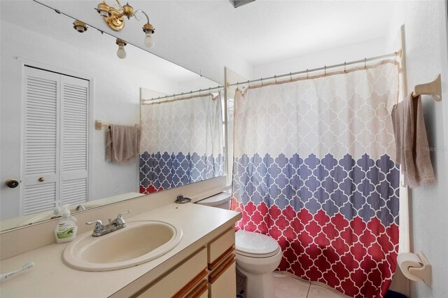 bathroom featuring tile patterned flooring, vanity, and toilet