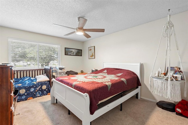 carpeted bedroom featuring ceiling fan and a textured ceiling