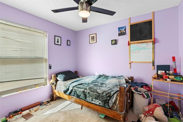 carpeted bedroom featuring ceiling fan and a textured ceiling