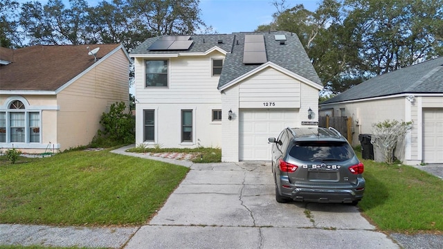 view of front of property with a garage, a front yard, and solar panels