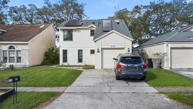 view of front of property featuring a front yard, solar panels, and a garage