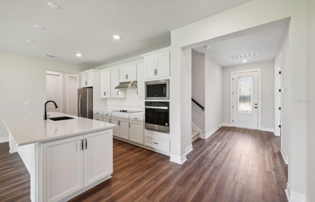 kitchen featuring sink, stainless steel appliances, dark hardwood / wood-style floors, an island with sink, and white cabinets