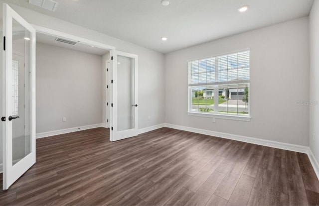 spare room featuring french doors and dark hardwood / wood-style flooring