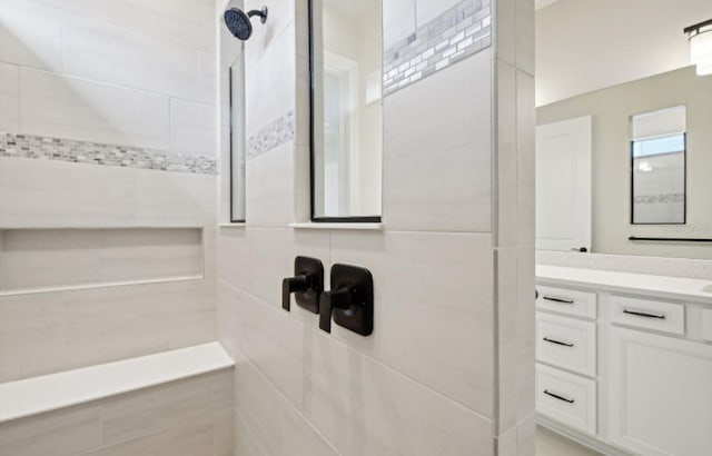 bathroom featuring a tile shower and vanity