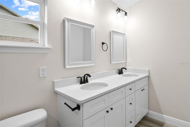 bathroom featuring vanity, hardwood / wood-style floors, and toilet