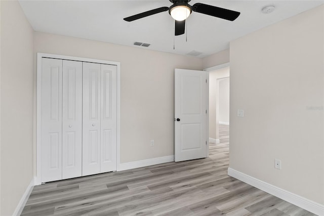 unfurnished bedroom featuring light hardwood / wood-style floors, ceiling fan, and a closet