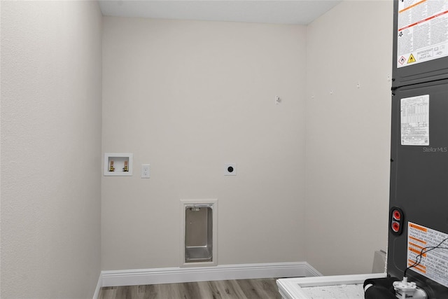 clothes washing area featuring hardwood / wood-style flooring, washer hookup, and hookup for an electric dryer