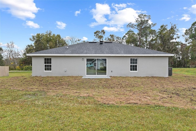 back of house with central AC and a lawn