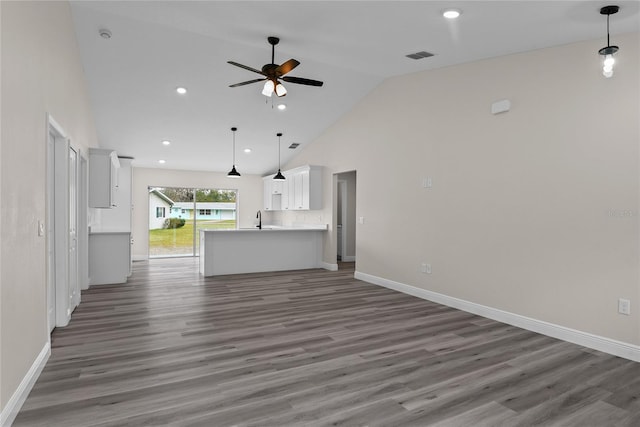 unfurnished living room featuring ceiling fan, high vaulted ceiling, dark hardwood / wood-style flooring, and sink