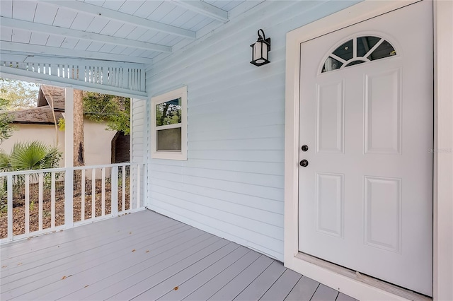 view of exterior entry featuring covered porch