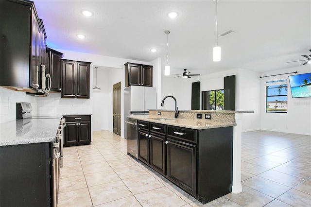 kitchen with sink, hanging light fixtures, light tile patterned floors, an island with sink, and stainless steel appliances