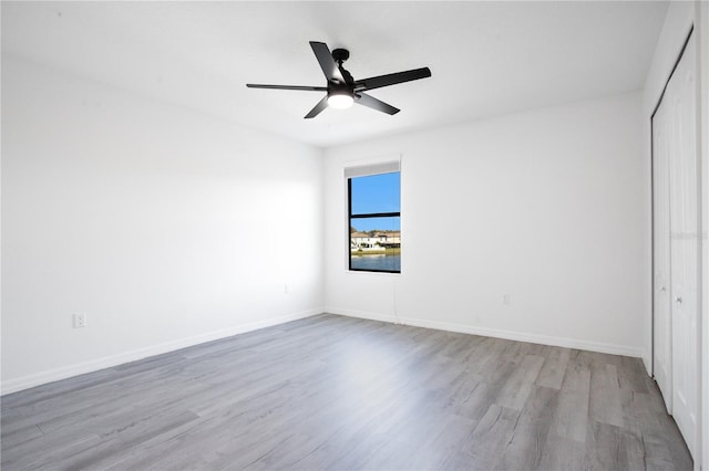 unfurnished bedroom with ceiling fan, a closet, and light wood-type flooring