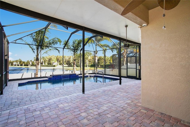 view of pool with a patio, a water view, ceiling fan, and a lanai