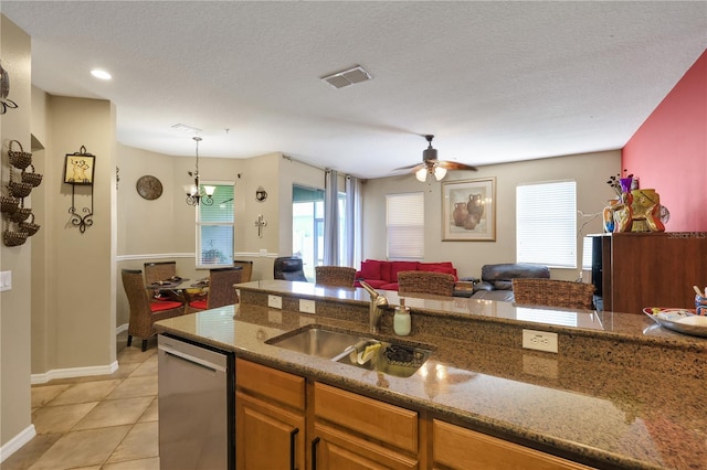 kitchen featuring sink, light tile patterned flooring, stainless steel dishwasher, and a textured ceiling