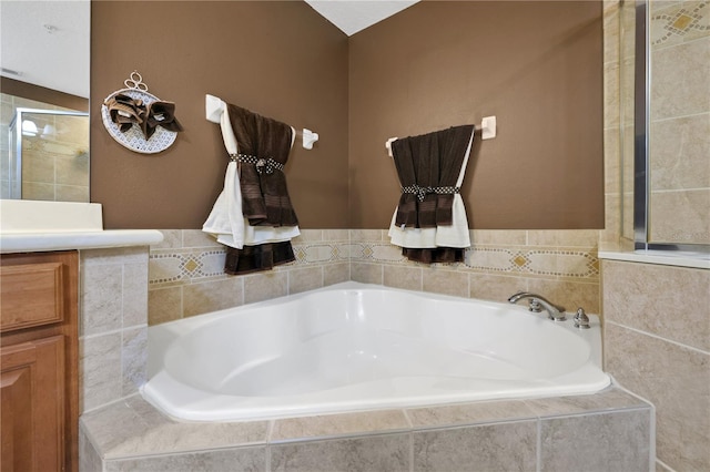 bathroom featuring vanity and tiled tub