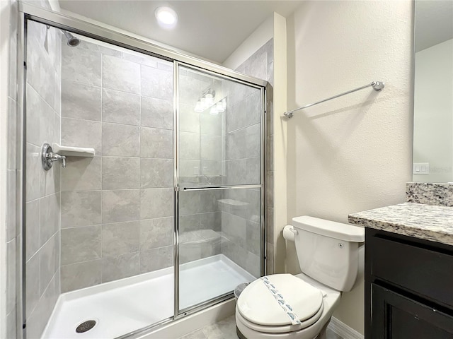 bathroom featuring toilet, vanity, and walk in shower