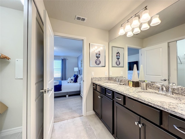 bathroom with tile patterned floors, vanity, and a textured ceiling