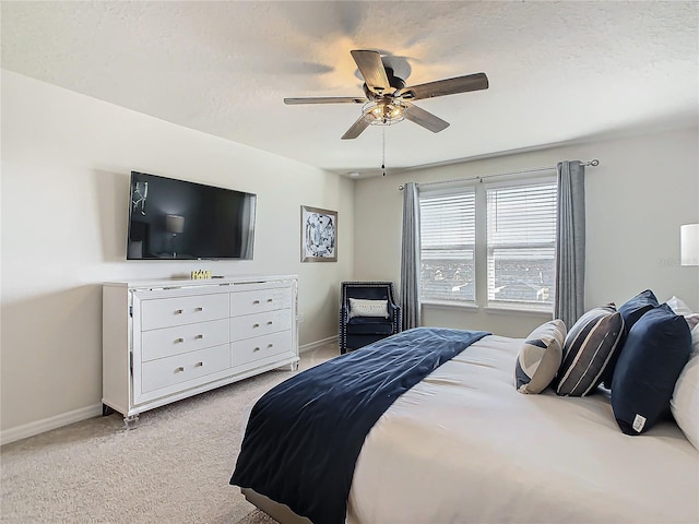 carpeted bedroom featuring ceiling fan and a textured ceiling