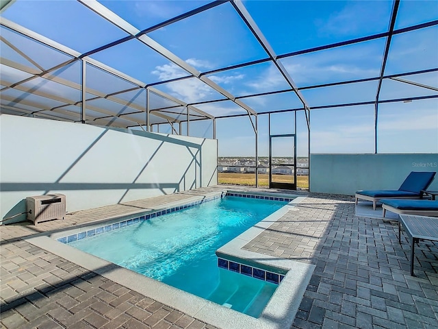 view of swimming pool with a patio area and a lanai