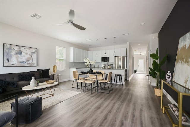 living room with ceiling fan and light hardwood / wood-style floors