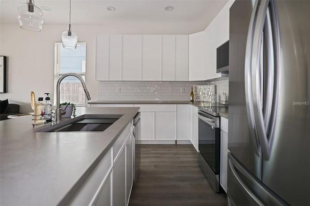 kitchen with sink, white cabinets, decorative light fixtures, and appliances with stainless steel finishes