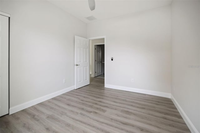 spare room with ceiling fan and light wood-type flooring