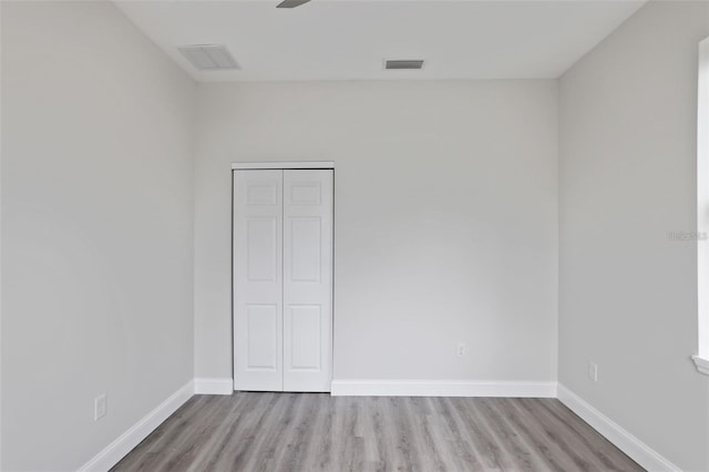 unfurnished bedroom with ceiling fan, light hardwood / wood-style floors, and a closet