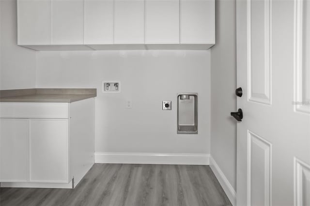 laundry room with cabinets, washer hookup, light hardwood / wood-style flooring, and electric dryer hookup